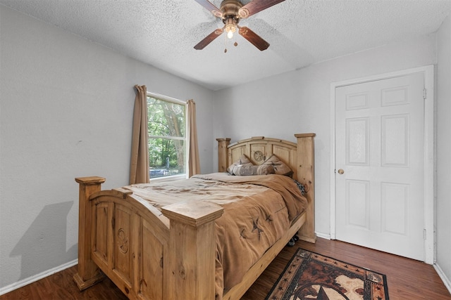 3812 Acree St, Beverly Hills, TX 76711 - bedroom featuring dark wood-type flooring, a textured ceiling, baseboards, and ceiling fan