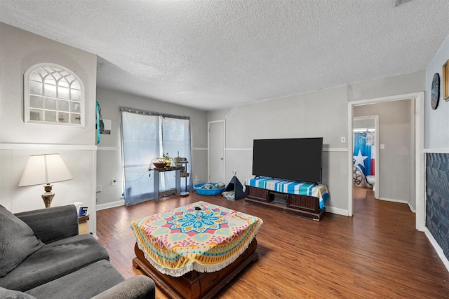 3812 Acree St, Beverly Hills, TX 76711 - living room with wood finished floors, a textured ceiling, and baseboards
