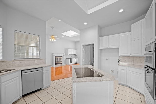 12020 Younger Ct, Azle, TX 76020 - kitchen featuring stainless steel appliances, a skylight, light tile patterned floors, tasteful backsplash, and recessed lighting