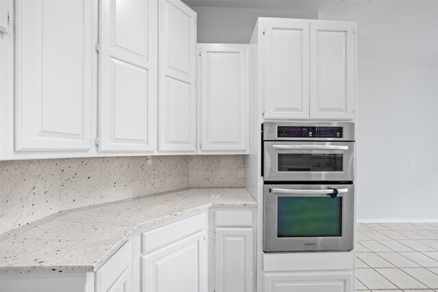 12020 Younger Ct, Azle, TX 76020 - kitchen featuring stainless steel double oven, light tile patterned floors, white cabinetry, light stone counters, and decorative backsplash