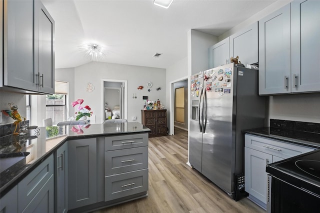 2701 Mims St, Fort Worth, TX 76112 - kitchen featuring stainless steel fridge with ice dispenser, a peninsula, light wood-style flooring, black / electric stove, and dark stone countertops