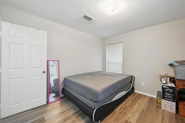 2701 Mims St, Fort Worth, TX 76112 - bedroom with light wood-type flooring, a textured ceiling, and baseboards