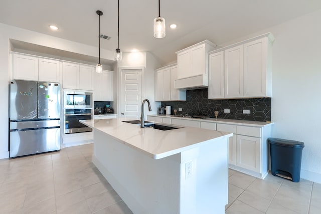 108 Laverna Ln, Hickory Creek, TX 75065 - kitchen with appliances with stainless steel finishes, a sink, backsplash, a kitchen island with sink, and light tile patterned floors