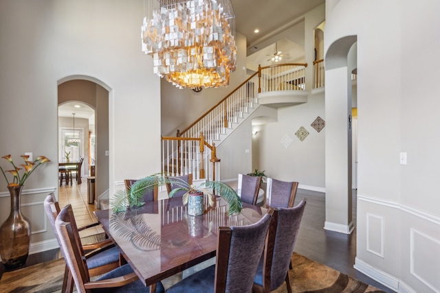 5736 New Castle Dr, Richardson, TX 75082 - dining room with arched walkways, stairs, a high ceiling, wood finished floors, and a chandelier