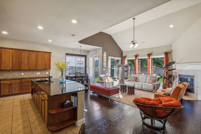 5736 New Castle Dr, Richardson, TX 75082 - living area with a ceiling fan, a fireplace, recessed lighting, vaulted ceiling, and light wood-type flooring