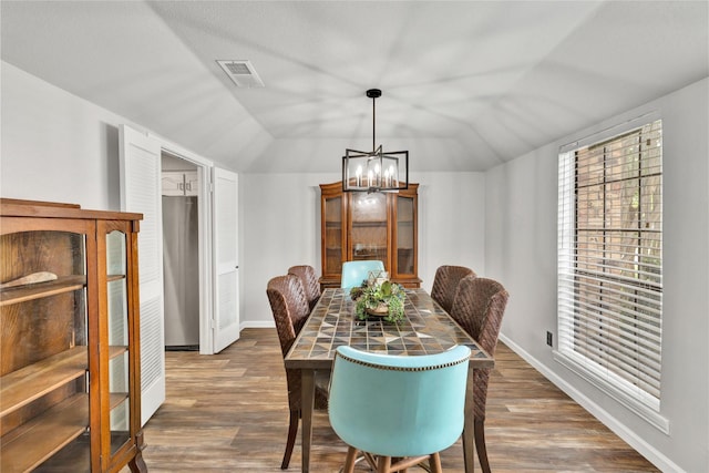 1603 Versailles Dr, Richardson, TX 75081 - dining room with vaulted ceiling, a chandelier, wood finished floors, and baseboards
