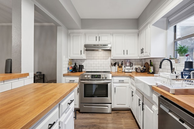 223 Mccarley Pl, Mckinney, TX 75071 - kitchen with butcher block countertops, appliances with stainless steel finishes, under cabinet range hood, and decorative backsplash