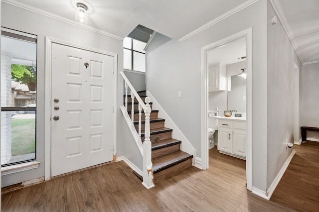 223 Mccarley Pl, Mckinney, TX 75071 - entrance foyer with crown molding, light wood finished floors, stairway, and baseboards