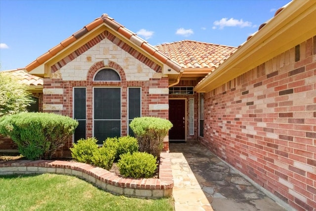 810 W Lonesome Dove Trl, Arlington, TX 76001 - view of exterior entry featuring a tiled roof and brick siding