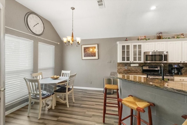 810 W Lonesome Dove Trl, Arlington, TX 76001 - dining space with vaulted ceiling, light wood finished floors, baseboards, and a chandelier