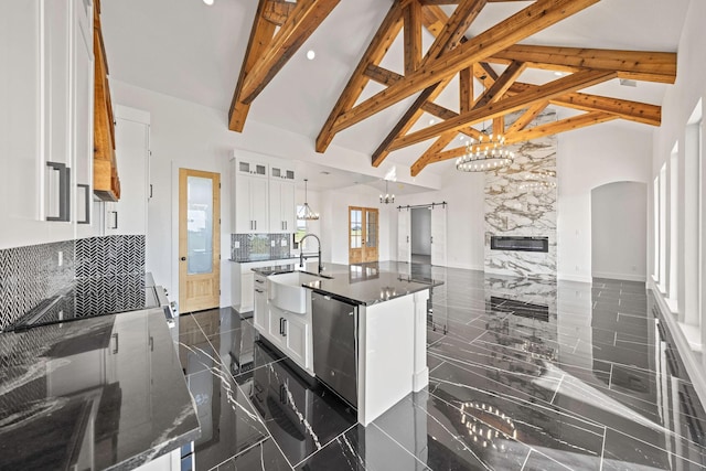 10611 Millet Ln, Venus, TX 76084 - kitchen with high vaulted ceiling, a sink, a chandelier, arched walkways, and white cabinets