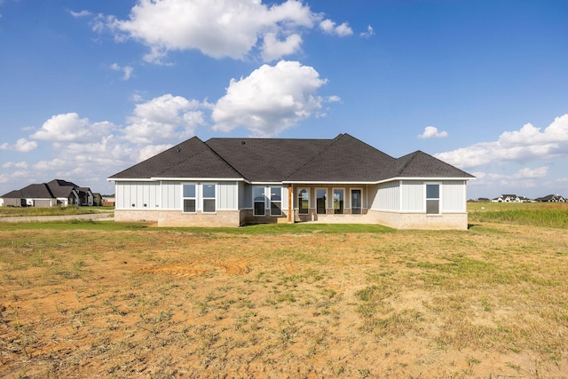 10611 Millet Ln, Venus, TX 76084 - back of house featuring board and batten siding, a shingled roof, a yard, and brick siding