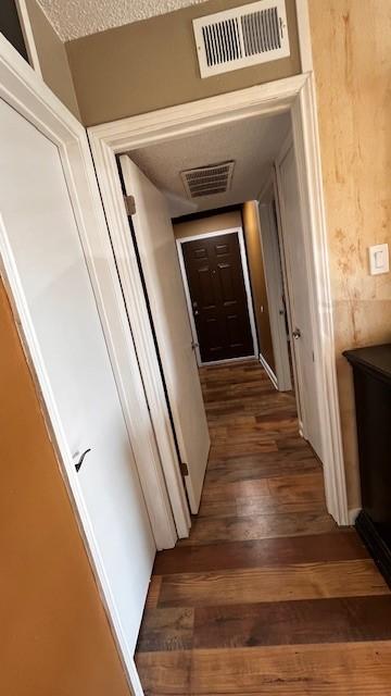2840 Patricia Ln Unit 104, Garland, TX 75041 - hall featuring wood finished floors and a textured ceiling