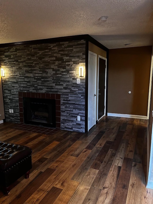 2840 Patricia Ln Unit 104, Garland, TX 75041 - unfurnished living room with a textured ceiling, wood finished floors, a fireplace, and baseboards