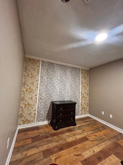 2840 Patricia Ln Unit 104, Garland, TX 75041 - unfurnished room featuring wood-type flooring, baseboards, and wallpapered walls