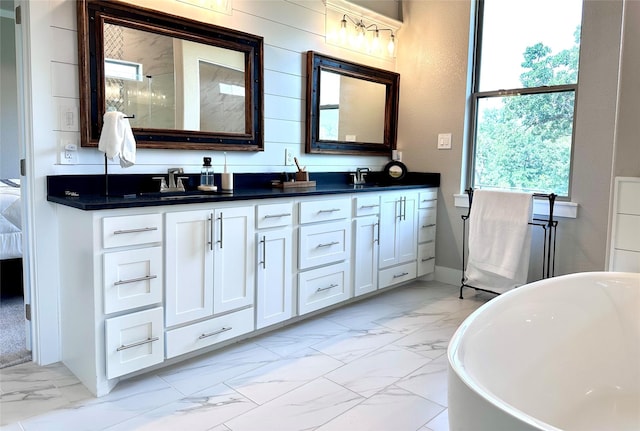 180 Cant Miss, Gordon, TX 76453 - bathroom with marble look tiles, double vanity, a freestanding tub, and baseboards