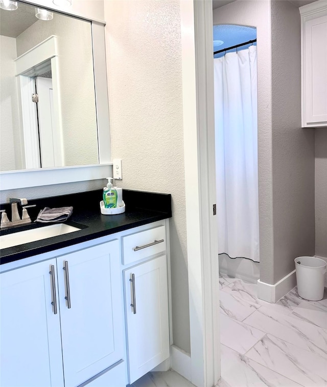 180 Cant Miss, Gordon, TX 76453 - bathroom featuring marble look tiles, vanity, toilet, and baseboards
