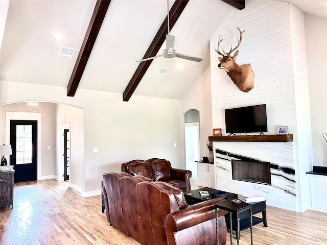 180 Cant Miss, Gordon, TX 76453 - living room with arched walkways, a ceiling fan, beam ceiling, light wood-style flooring, and a premium fireplace