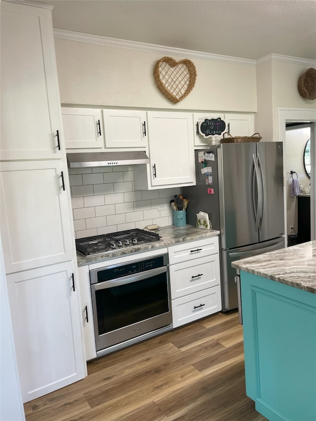 2620 County Road 1102, Grandview, TX 76050 - kitchen with appliances with stainless steel finishes, ornamental molding, decorative backsplash, white cabinets, and under cabinet range hood