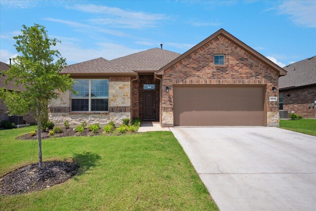 5213 Meadow Ln, Krum, TX 76249 - view of front of house with central AC, an attached garage, driveway, a front yard, and stone siding