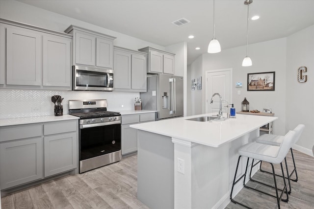 5213 Meadow Ln, Krum, TX 76249 - kitchen featuring appliances with stainless steel finishes, a sink, gray cabinets, light wood finished floors, and recessed lighting