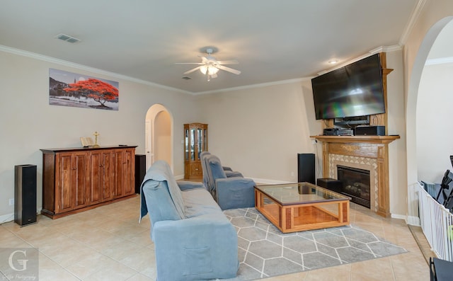 4002 Wilderness Ln, Bossier City, LA 71111 - living room with arched walkways, light tile patterned floors, ceiling fan, ornamental molding, and a tiled fireplace