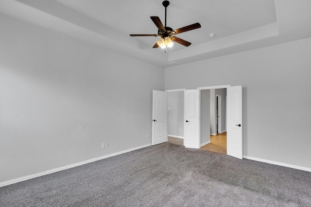 417 Sagebrush Ln, Waxahachie, TX 75165 - unfurnished bedroom featuring carpet, baseboards, a ceiling fan, a tray ceiling, and a towering ceiling