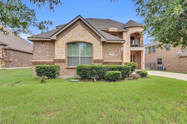 417 Sagebrush Ln, Waxahachie, TX 75165 - french country style house with central air condition unit, a front yard, brick siding, stone siding, and a balcony