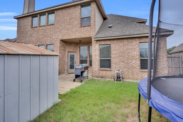 417 Sagebrush Ln, Waxahachie, TX 75165 - rear view of house featuring a trampoline, a patio area, a chimney, and brick siding