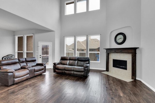 417 Sagebrush Ln, Waxahachie, TX 75165 - living room featuring a high ceiling, wood finished floors, a tiled fireplace, and baseboards
