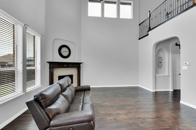 417 Sagebrush Ln, Waxahachie, TX 75165 - living room with a high ceiling, arched walkways, wood finished floors, baseboards, and a fireplace