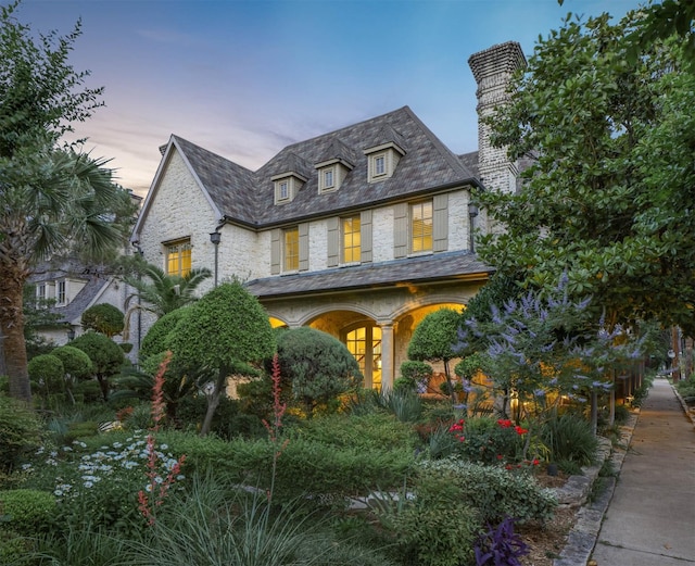 2900 Amherst Ave, University Park, TX 75225 - view of front of home with a high end roof, a chimney, stone siding, and covered porch