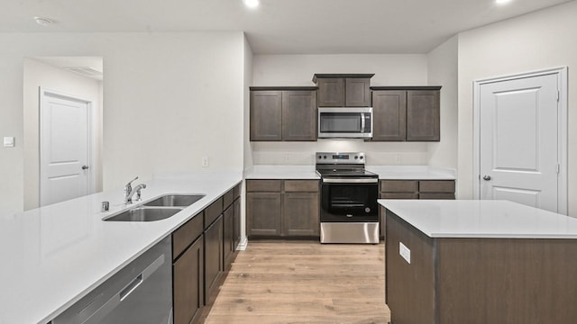 504 Drake Dr, Ferris, TX 75125 - kitchen featuring appliances with stainless steel finishes, light wood-type flooring, light countertops, recessed lighting, and dark brown cabinets