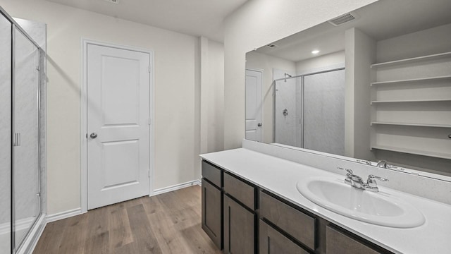 504 Drake Dr, Ferris, TX 75125 - bathroom with wood finished floors, a stall shower, and vanity