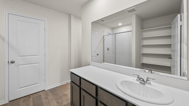 504 Drake Dr, Ferris, TX 75125 - bathroom featuring vanity, wood finished floors, and a stall shower