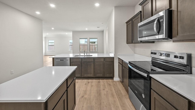 504 Drake Dr, Ferris, TX 75125 - kitchen featuring appliances with stainless steel finishes, light wood-style flooring, light countertops, recessed lighting, and a peninsula