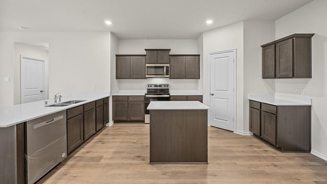 504 Drake Dr, Ferris, TX 75125 - kitchen featuring appliances with stainless steel finishes, a peninsula, a center island, light wood-type flooring, and light countertops