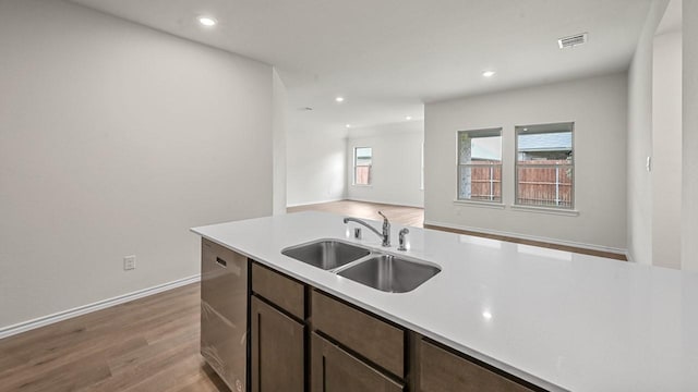 504 Drake Dr, Ferris, TX 75125 - kitchen featuring light countertops, light wood-style flooring, open floor plan, dark brown cabinets, and recessed lighting