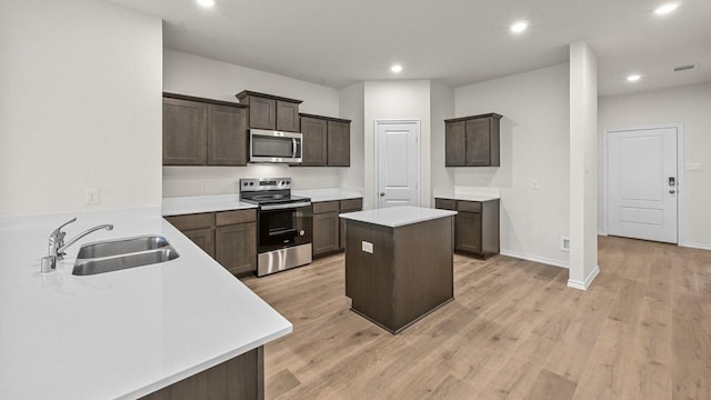 504 Drake Dr, Ferris, TX 75125 - kitchen featuring appliances with stainless steel finishes, dark brown cabinetry, recessed lighting, a center island, and light countertops