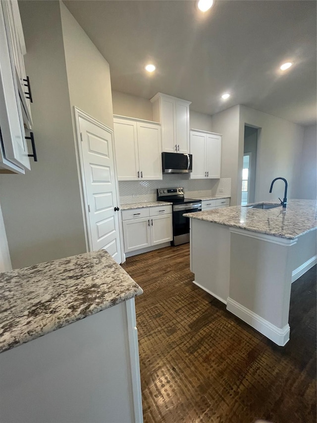 6113 Rodin Dr, Royse City, TX 78189 - kitchen with stainless steel appliances, a sink, light stone counters, white cabinetry, and recessed lighting