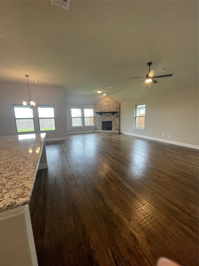 6113 Rodin Dr, Royse City, TX 78189 - unfurnished living room with baseboards, dark wood-type flooring, healthy amount of natural light, and a stone fireplace