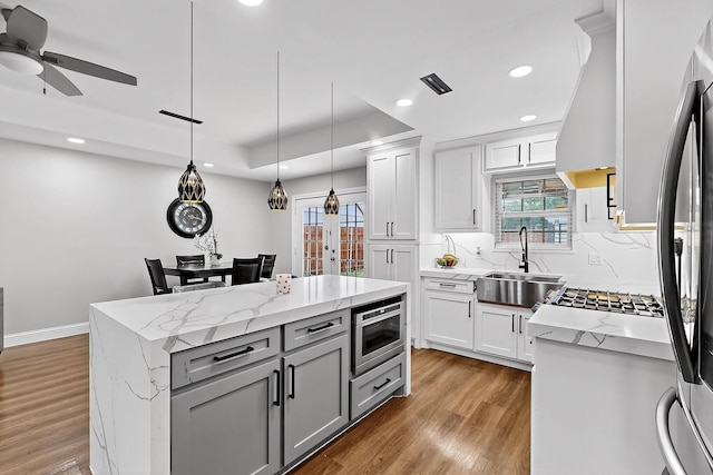 3039 Dutton Dr, Dallas, TX 75211 - kitchen with a sink, gray cabinetry, a center island, premium range hood, and light wood-style flooring