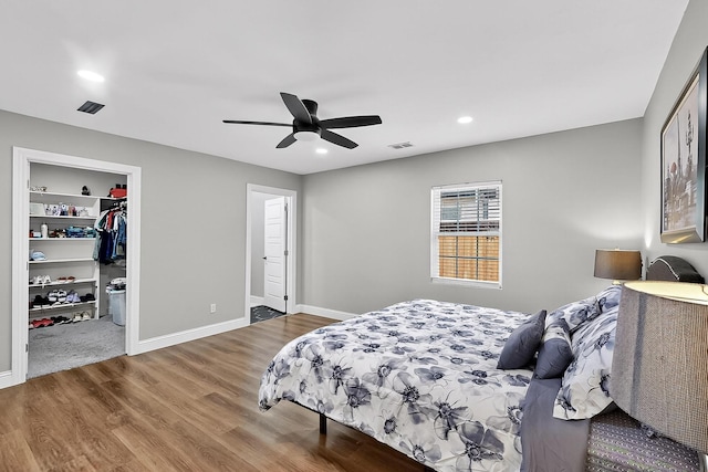 3039 Dutton Dr, Dallas, TX 75211 - bedroom featuring wood finished floors, a walk in closet, recessed lighting, baseboards, and a ceiling fan