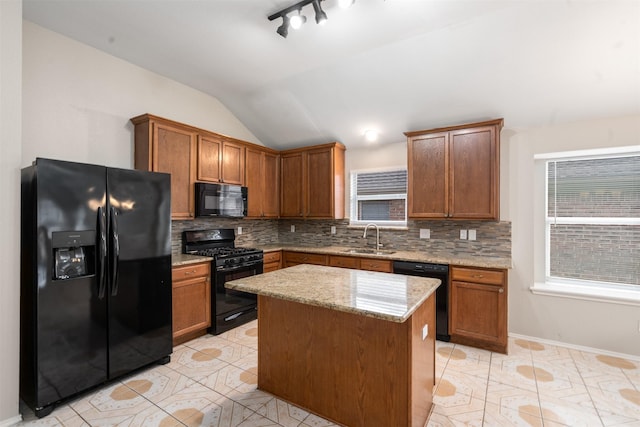 648 Tabasco Trl, Arlington, TX 76002 - kitchen with black appliances, a sink, decorative backsplash, vaulted ceiling, and light stone counters