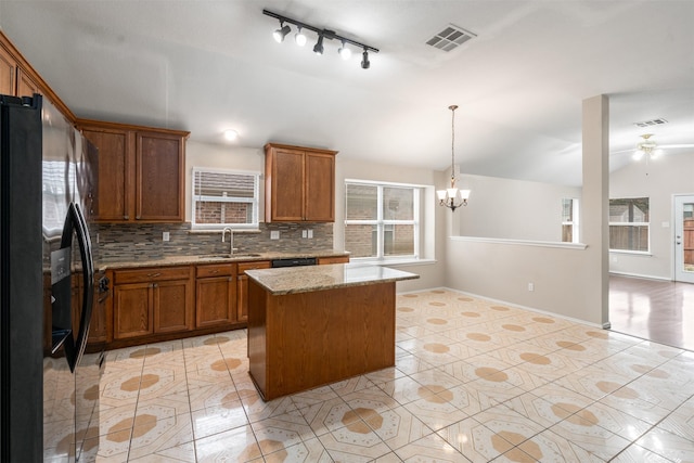 648 Tabasco Trl, Arlington, TX 76002 - kitchen with black appliances, a sink, brown cabinetry, track lighting, and a center island