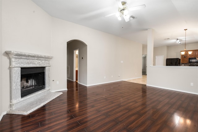 648 Tabasco Trl, Arlington, TX 76002 - unfurnished living room with wood finished floors, ceiling fan, arched walkways, and a fireplace with raised hearth