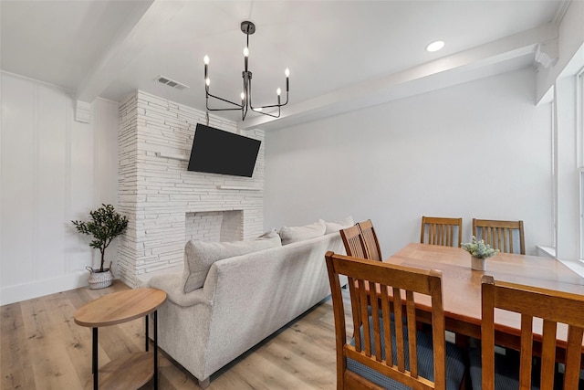 4100 N 30th St, Waco, TX 76708 - living area featuring a chandelier, light wood finished floors, beam ceiling, a stone fireplace, and recessed lighting