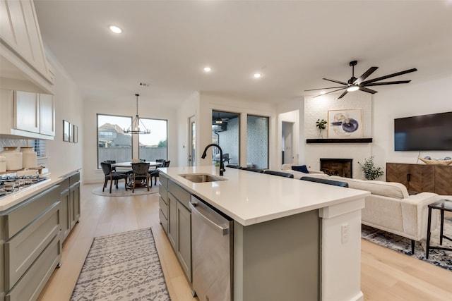 12104 Fairway Meadows Dr, Fort Worth, TX 76179 - kitchen with appliances with stainless steel finishes, gray cabinets, light wood-style flooring, a fireplace, and recessed lighting