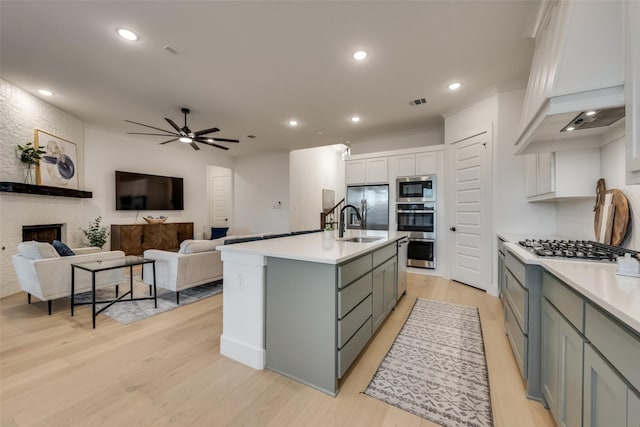 12104 Fairway Meadows Dr, Fort Worth, TX 76179 - kitchen with appliances with stainless steel finishes, custom range hood, light wood finished floors, light countertops, and white cabinets
