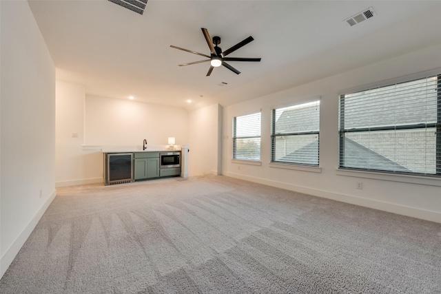 12104 Fairway Meadows Dr, Fort Worth, TX 76179 - unfurnished living room with beverage cooler, bar with sink, light carpet, and a ceiling fan